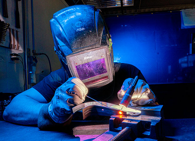 Man in helmet welding a part